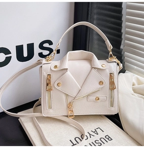 Detail of cream biker jacket style handbag with gold zippers and studded textured leather