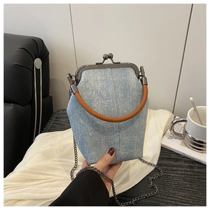 Close-up of light blue denim handbag with shiny rhinestones and leather handle