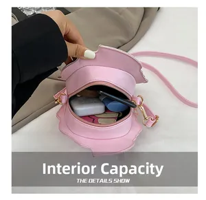 Internal view of pink strawberry shaped crossbody bag showing storage capacity for phone