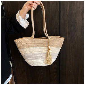 Macro detail of gradient woven tote with long round handles and tassel wooden bead charm