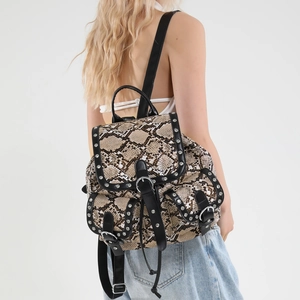 Fashionable snake skin print backpack for women with metal studs and punk style details
