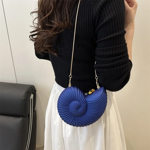 Navy blue nautilus shaped acrylic shell clutch bag with a delicate gold chain strap