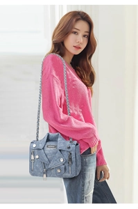 Detailed view of motorcycle jacket denim crossbody bag with silver studs and zippers