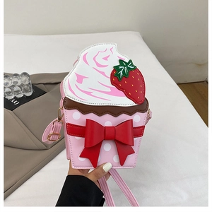 Detail of pink cupcake-shaped handbag featuring white dots and a large red bow decoration