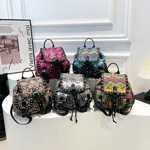 Chic snakeskin texture mini backpacks in five trendy colors on white display pedestals