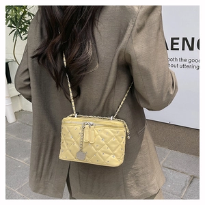 Close-up of pale yellow quilted crossbody bag with sparkling crystal embellishments