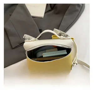 Top view of yellow and white box bag interior showing capacity for phone and makeup
