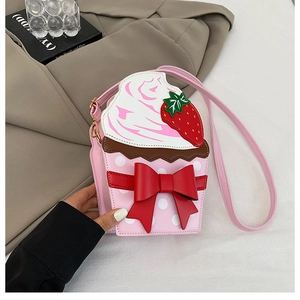 Detail of strawberry cupcake crossbody bag with red bow and white cream topping