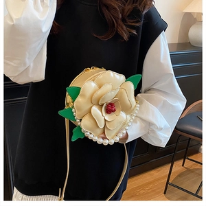 Detailed view of cream floral crossbody bag with layered petals and pearl trim accents