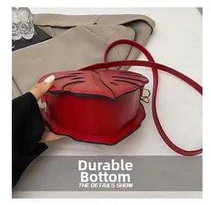 Macro detail of leaf-shaped handbag with wear-resistant bottom and red leather strap