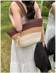 Close-up of tricolor woven tote bag with fringe wood bead detail and cotton rope texture