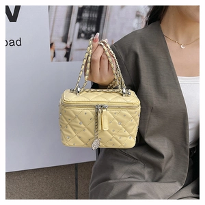 Detail of quilted leather mini bag with rhinestone accents and silver camellia charm