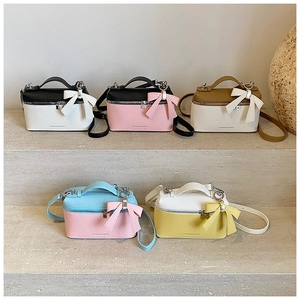 Detail view of mini crossbody vanity bags with bow charms in various color combinations