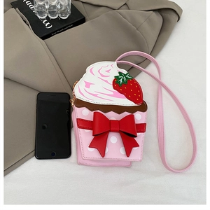 Detail of pink strawberry cupcake bag with red bow and white polka dots on plain surface