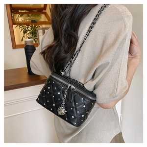 Close-up of black quilted bag with silver rhinestone accents and rose pendant detail