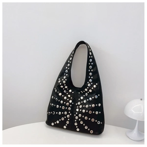 Detail of silver rivets on black leather hobo bag with vintage punk aesthetic