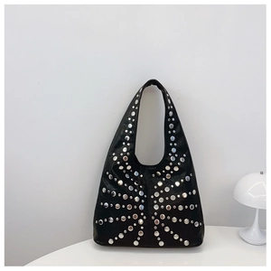 Detail of black leather hobo bag featuring silver rivets arranged in a sunburst pattern