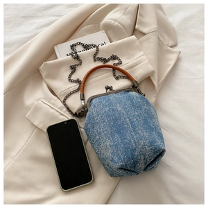 Macro shot of blue denim mini doctor bag with vintage bronze clasp and metal chain