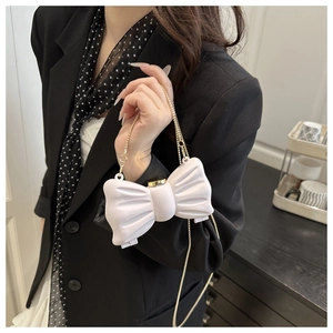 Détail du sac bandoulière blanc en forme de nœud 3D avec chaîne dorée pour femme