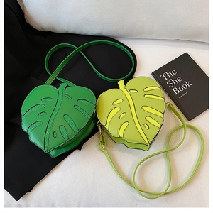 Detail of heart-shaped leaf crossbody bags in dark and light green leather texture