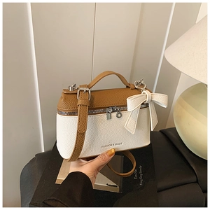 Detail of two-tone box bag with lychee grain leather and removable strap