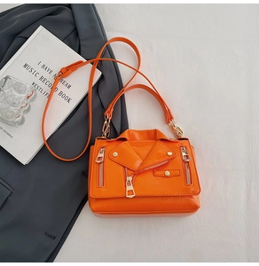 Detail of bright orange biker jacket style crossbody bag with metallic studs and zippers