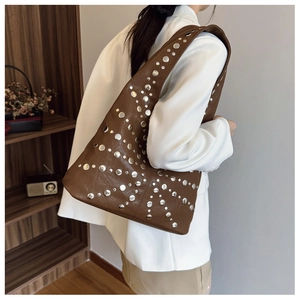 Brown rivet shoulder bag with silver star-shaped studs and retro aesthetic on a model