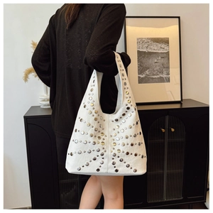 Makroaufnahme von Silbernieten und Premium-Lederstruktur an einer weißen Hobo-Tasche