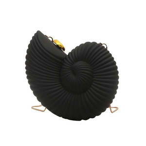 Detailed view of conch shaped black evening clutch with elegant gold metal hardware