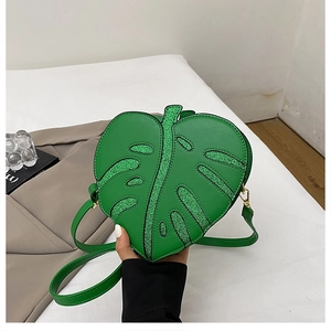 Detailed view of leaf shaped crossbody bag featuring sparkling green sequin veins