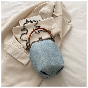 Detailed shot of denim handbag with rhinestones, metal chain strap and leather handle