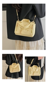 Detailed views of pale yellow motorcycle jacket style crossbody bag with metal rivets