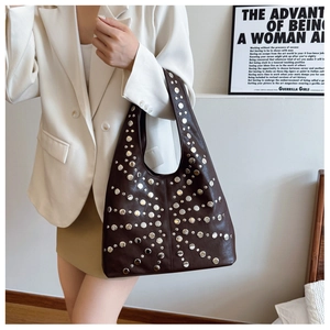Close-up of a dark brown tote bag with silver studs and polished synthetic leather