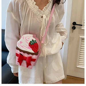 Detail of cute cupcake crossbody bag featuring a pink bow and strawberry embroidery