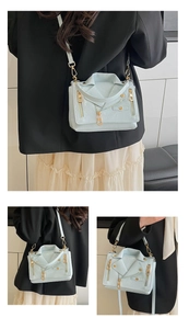 Detail of jacket-shaped crossbody bag with gold zippers and metal rivets decoration