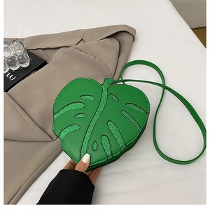 Detail of green leaf-shaped crossbody bag with glitter accents and embossed veins