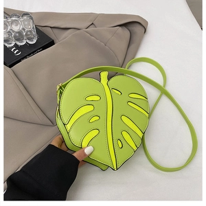 Macro detail of leaf-shaped crossbody bag featuring monstera texture and stitching