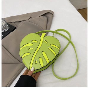 Detail of green monstera leaf shaped crossbody bag featuring realistic texture and vein design