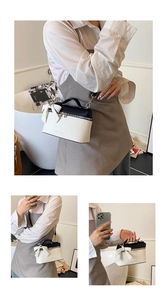 Detailed close-up of bow knot design on black and white contrast leather crossbody bag