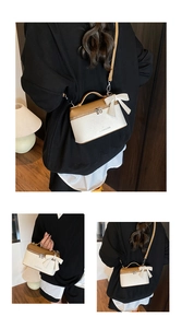 Detail of a vintage contrast box bag featuring a cream bow and lychee grain texture
