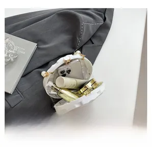 Interior view of marble texture acrylic evening bag showing phone and cosmetic storage