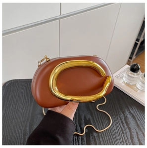 Close-up of brown leather bag featuring a large gold C-clasp and metallic chain strap