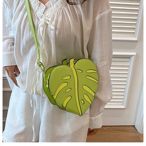 Detail of green monstera leaf crossbody bag featuring hollow veins and zipper closure