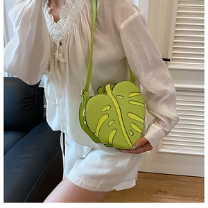 Detailed view of monstera leaf shaped crossbody bag in bright avocado green leather