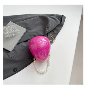 Dettaglio borsa a palloncino in acrilico marmo rosa con manico di perle e catena