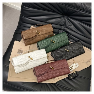 Cinq sacs à bandoulière tressés en marron, vert, noir, blanc et bordeaux sur cuir noir