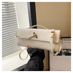 Détail du sac à bandoulière tressé blanc avec verrou rotatif doré et fine sangle