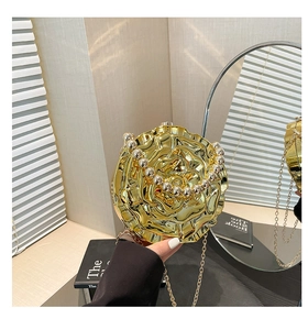 Detailed view of golden 3D rose evening bag with pearl handle and metal chain strap