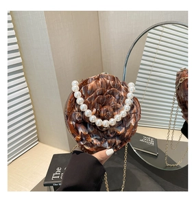 Detailed view of acrylic rose evening bag with tortoise texture and pearl handle