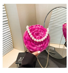 Detailed view of rose-shaped acrylic evening bag with pearl handle and marble texture